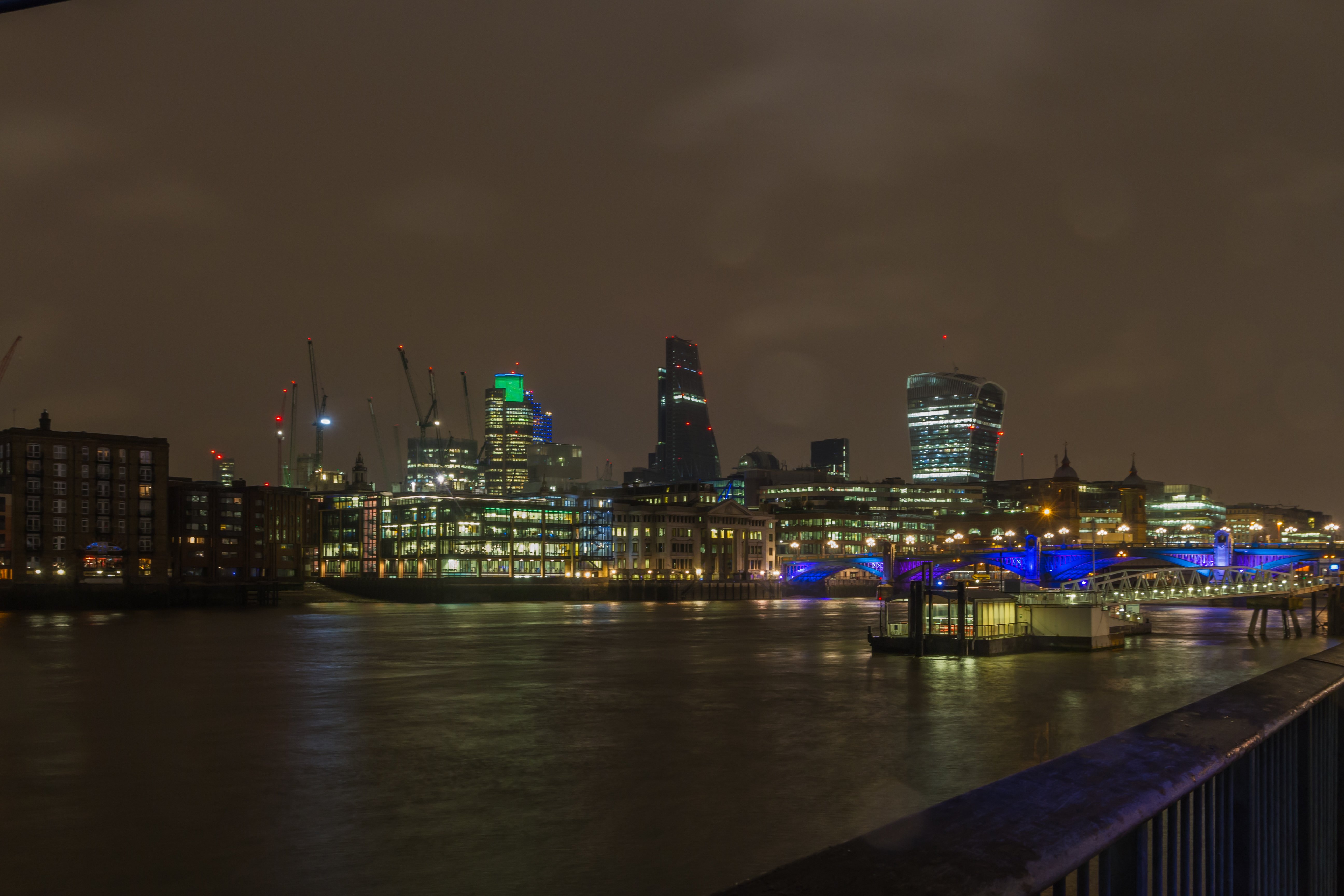 The City of London skyline at night, seen across the Thames near Southwark Bridge
